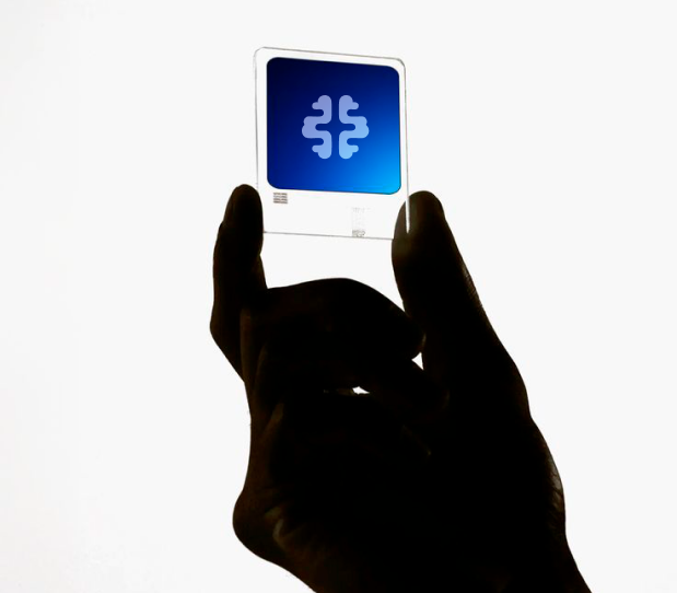 A hand holding a transparent card with the OneBrain symbol